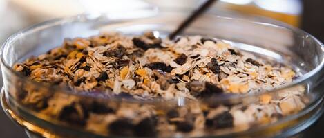 A glass bowl filled with a mix of oats and dried fruits.