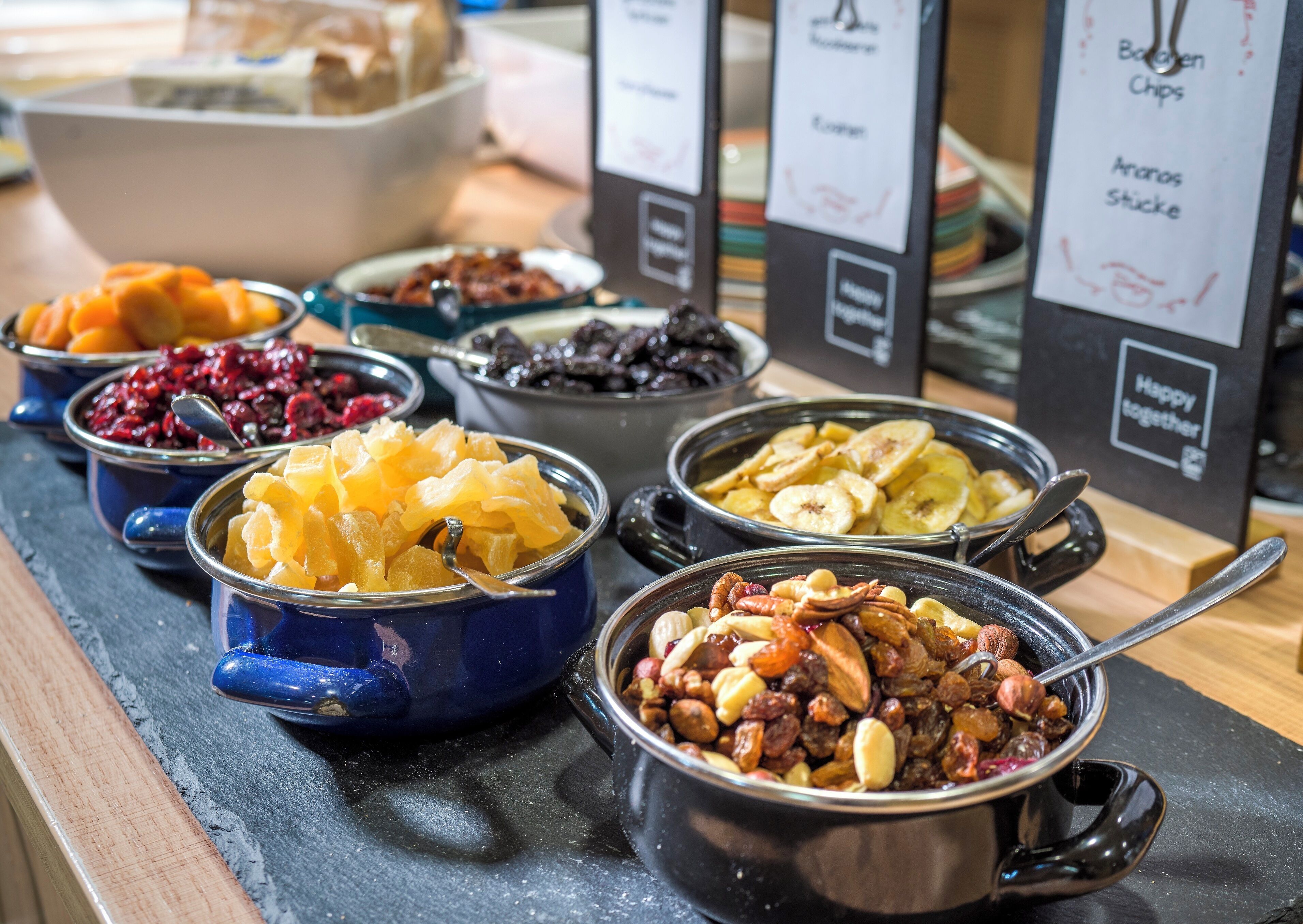 Un buffet proposant une variété de plats, notamment des fruits, des noix et des chips.