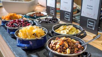 Un buffet proposant une variété de plats, notamment des fruits, des noix et des chips.