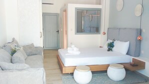 A modern bedroom with a bed, a sofa, and a small table.