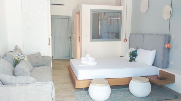 Un dormitorio moderno con una cama, un sofá y una pequeña mesa.