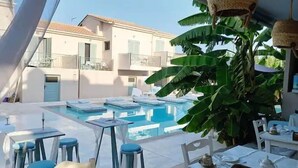 A pool area with multiple swimming pools, lounge chairs, and tables.