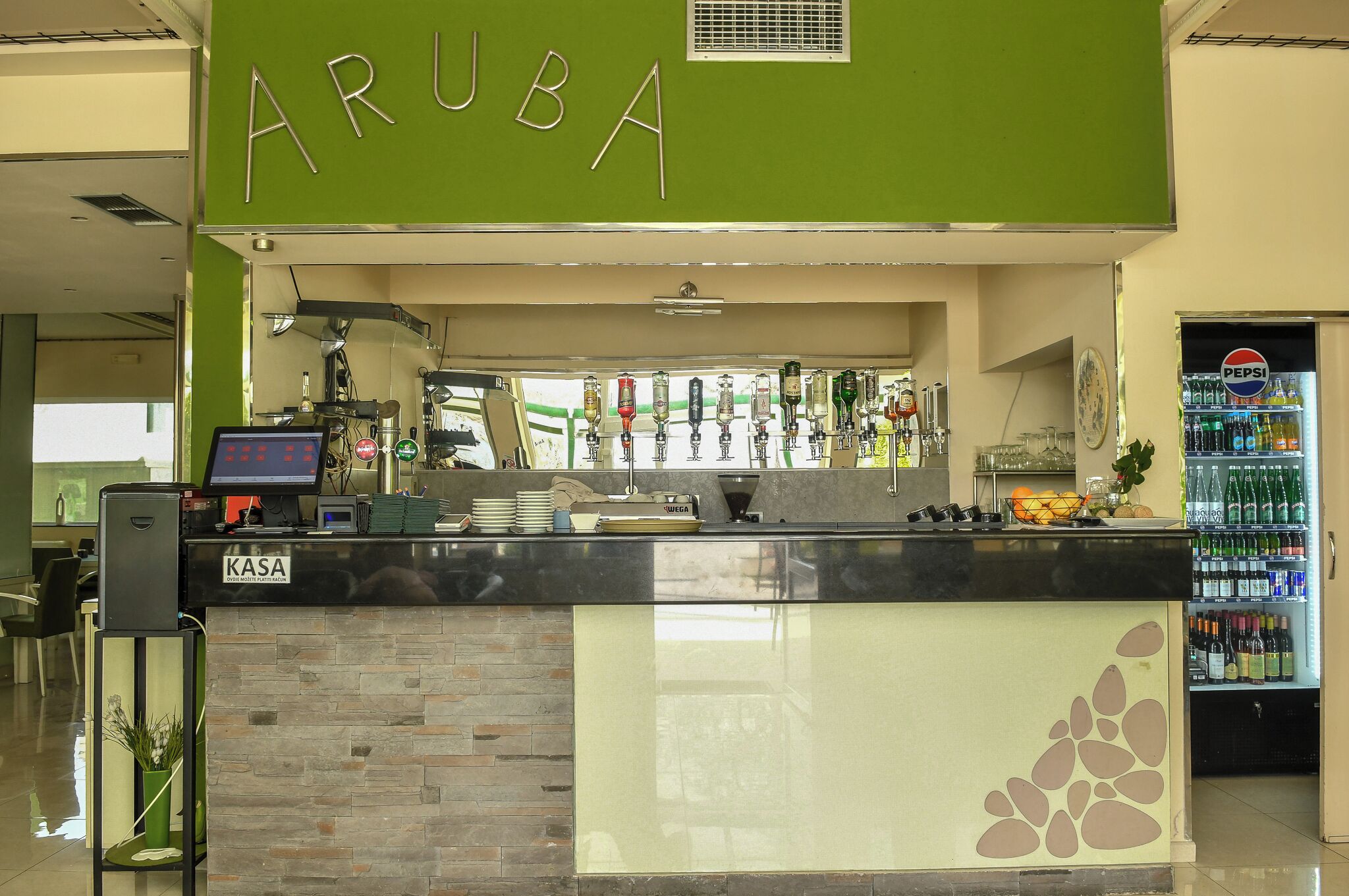 A bar area with a sign reading 'ARUBA' and a Pepsi refrigerator.