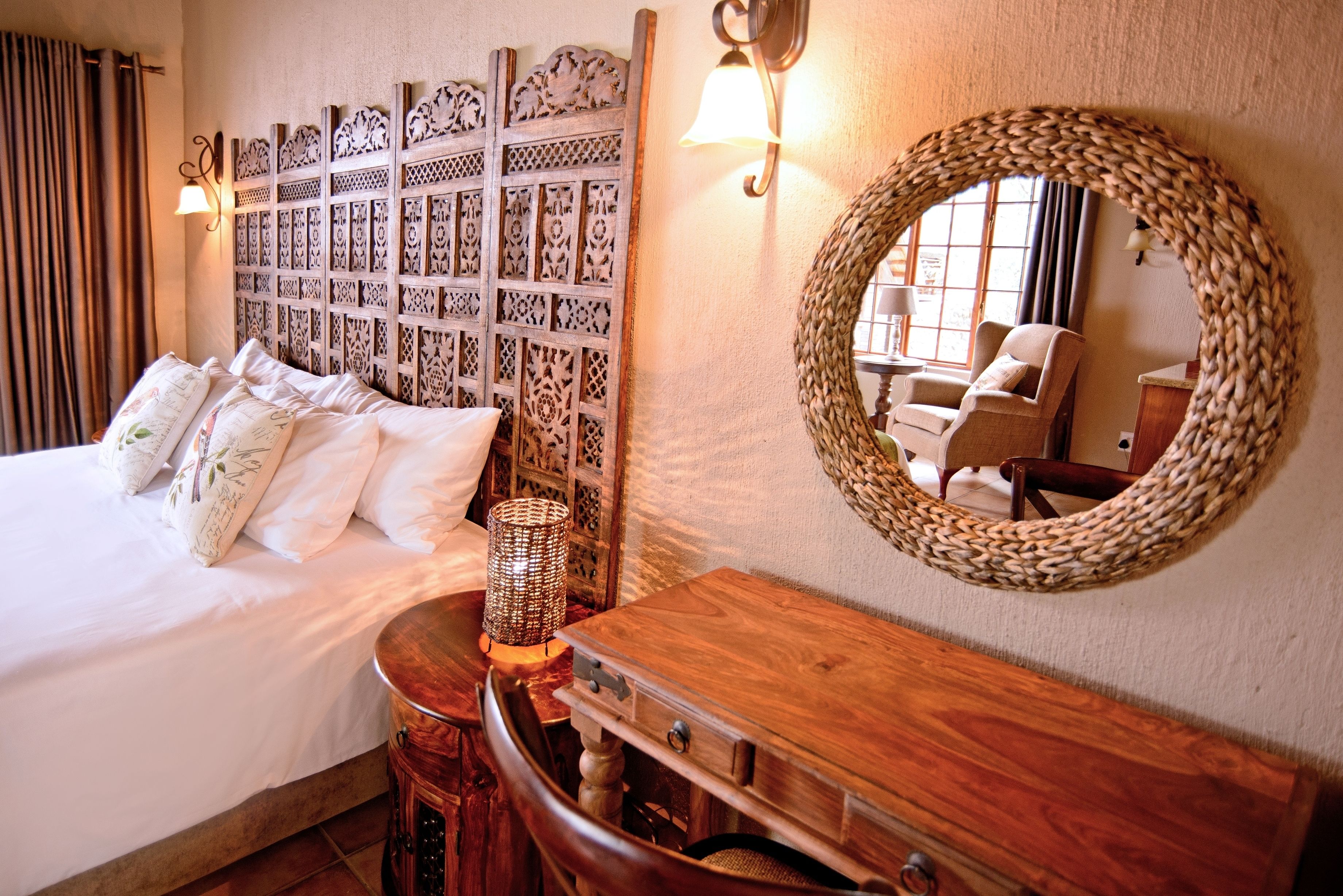 A neatly arranged bedroom with a bed, bedside table, lamp, and a decorative wall panel.