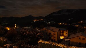 A nighttime view of a town with buildings and mountains in the background.