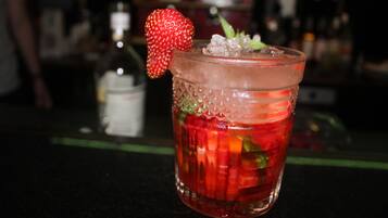 A cocktail with a strawberry garnish in a textured glass.