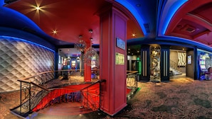 A casino interior with a red and blue color scheme, a grand staircase, and slot machines. - EfBet Hotel (Varna)