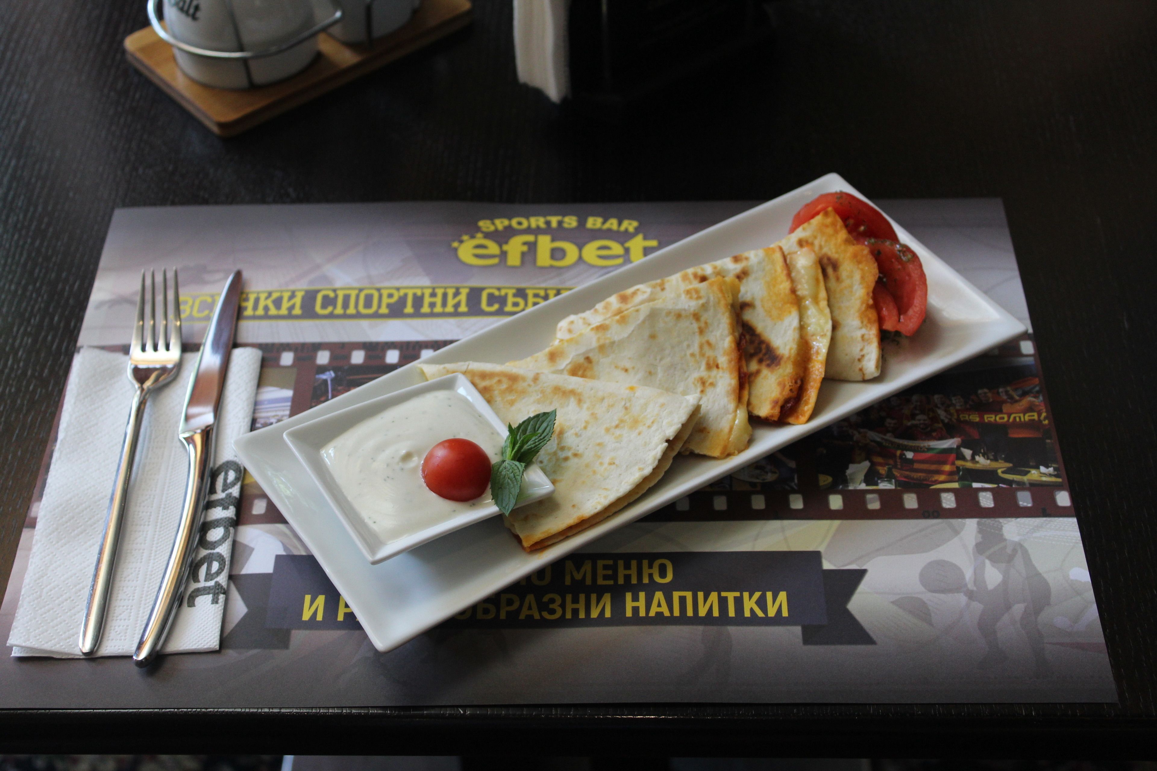 A plate of food with a fork and knife on a table with a placemat.