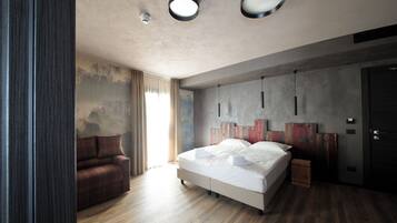 Une chambre à coucher moderne avec un grand lit, un canapé et un plancher en bois.