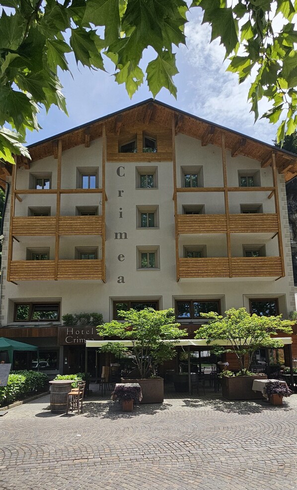 Un hotel con fachada simétrica, varios balcones y una entrada central.