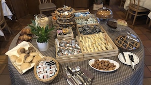 Una mesa de buffet con diversos alimentos, incluyendo pasteles, frutos secos y salsas.