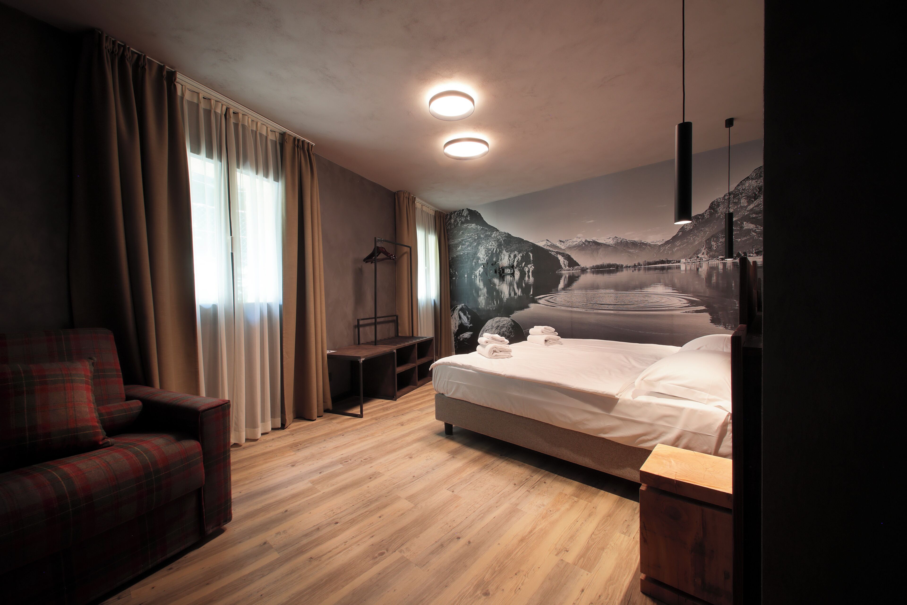 Una habitación de hotel con una cama, una silla, un escritorio y un armario.
