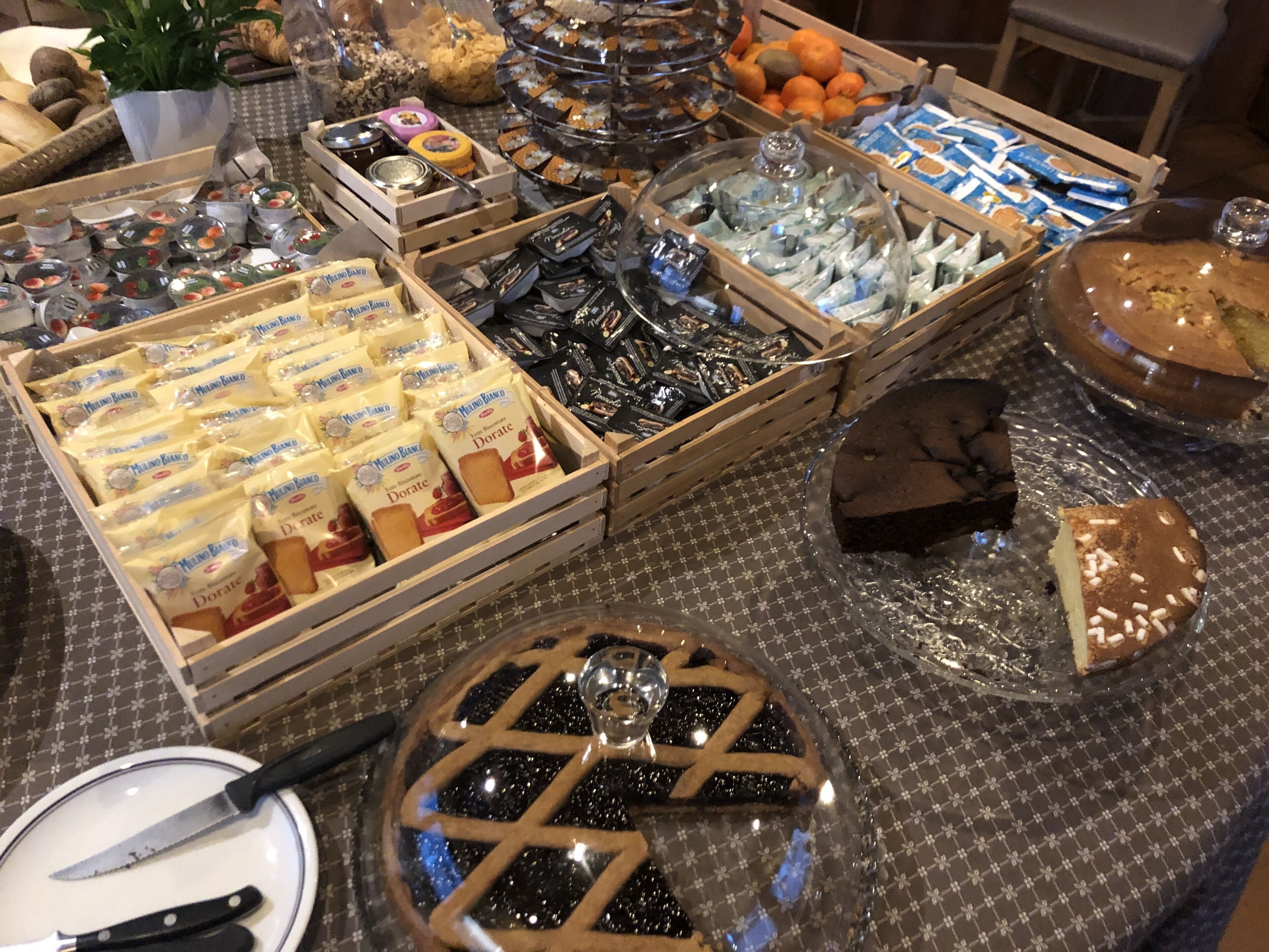 A buffet table with various food items including Dorate cheese, pastries, and a pie.