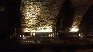 A dimly lit bar area with stone walls and a long counter.