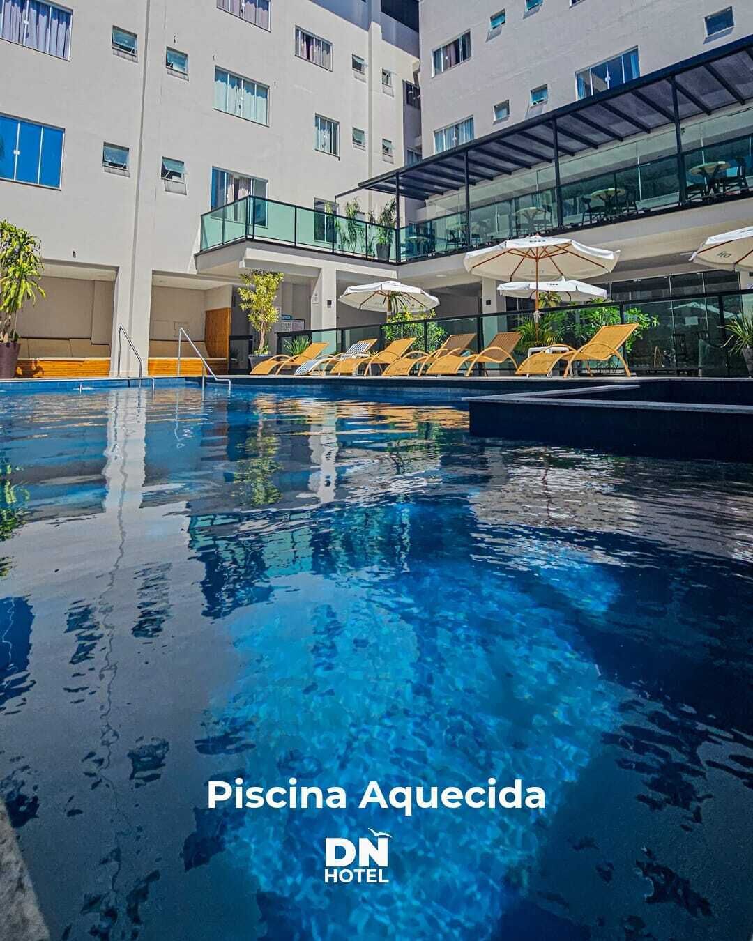 Una piscina al aire libre, sillones reclinables de piscina