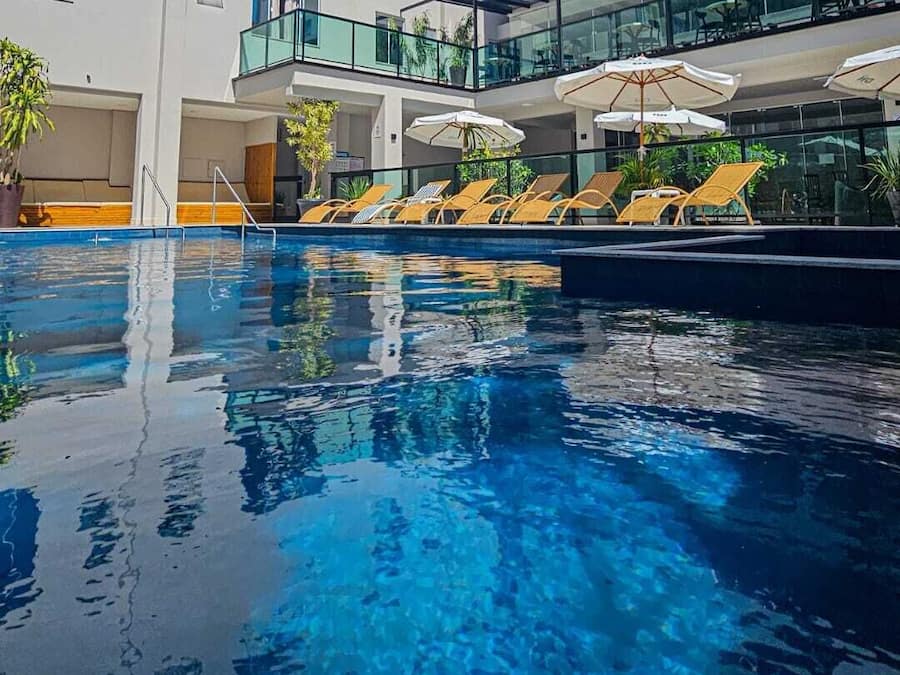 Una piscina al aire libre, sillones reclinables de piscina