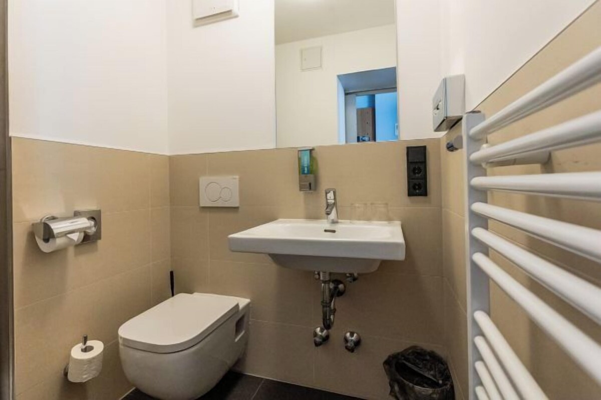 A small bathroom with a toilet, sink, and towel rack.