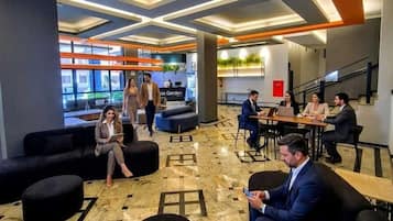 Un lobby moderno con zonas de estar, una recepción y una escalera.