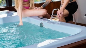 Una pareja en un jacuzzi con vista a la ciudad.