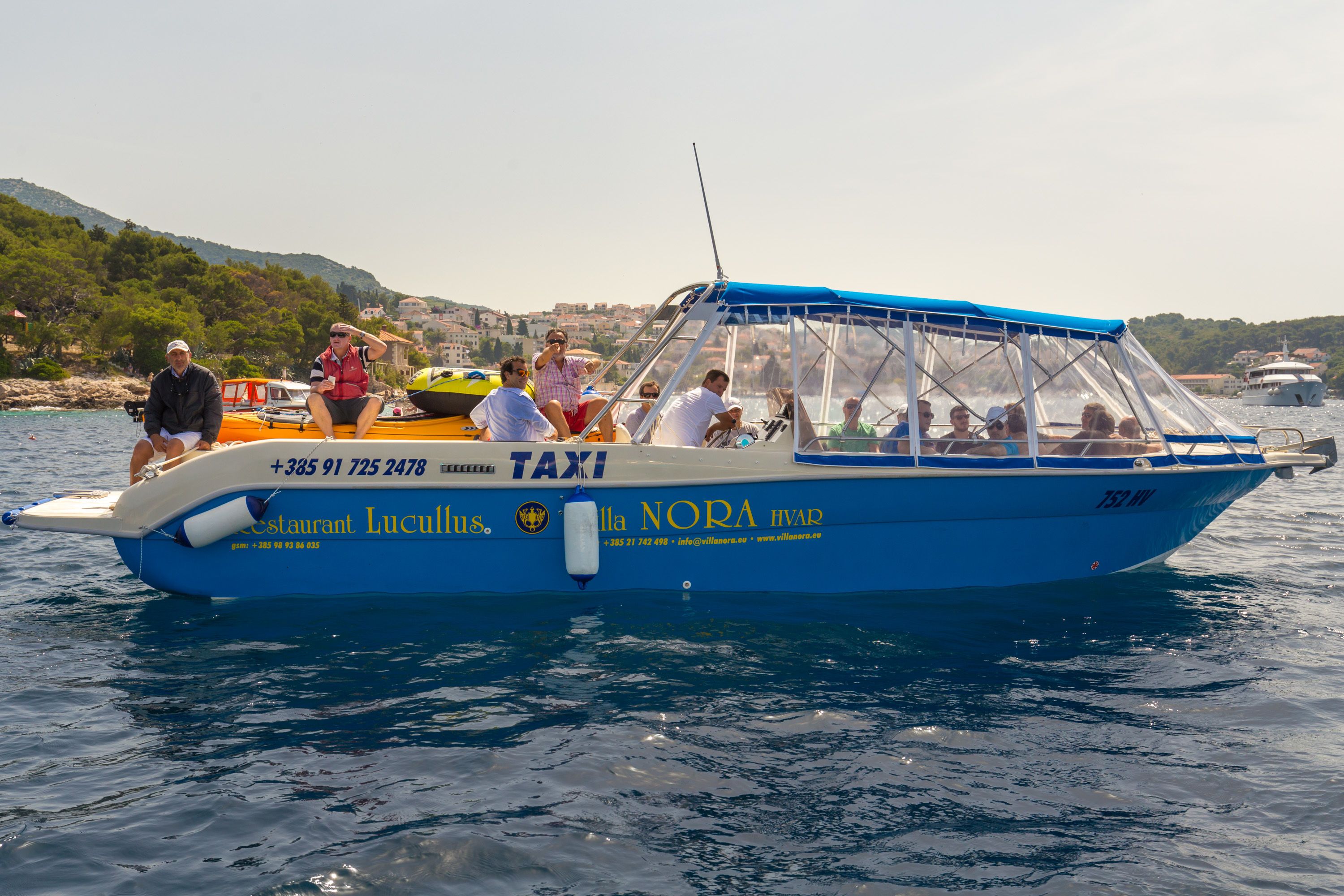 A blue boat with "TAXI" and "Lucius" written on it, indicating it is a taxi service.