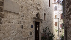 A narrow stone building with a wooden door and a small staircase leading to the entrance. - Hotel Villa Nora (Hvar)