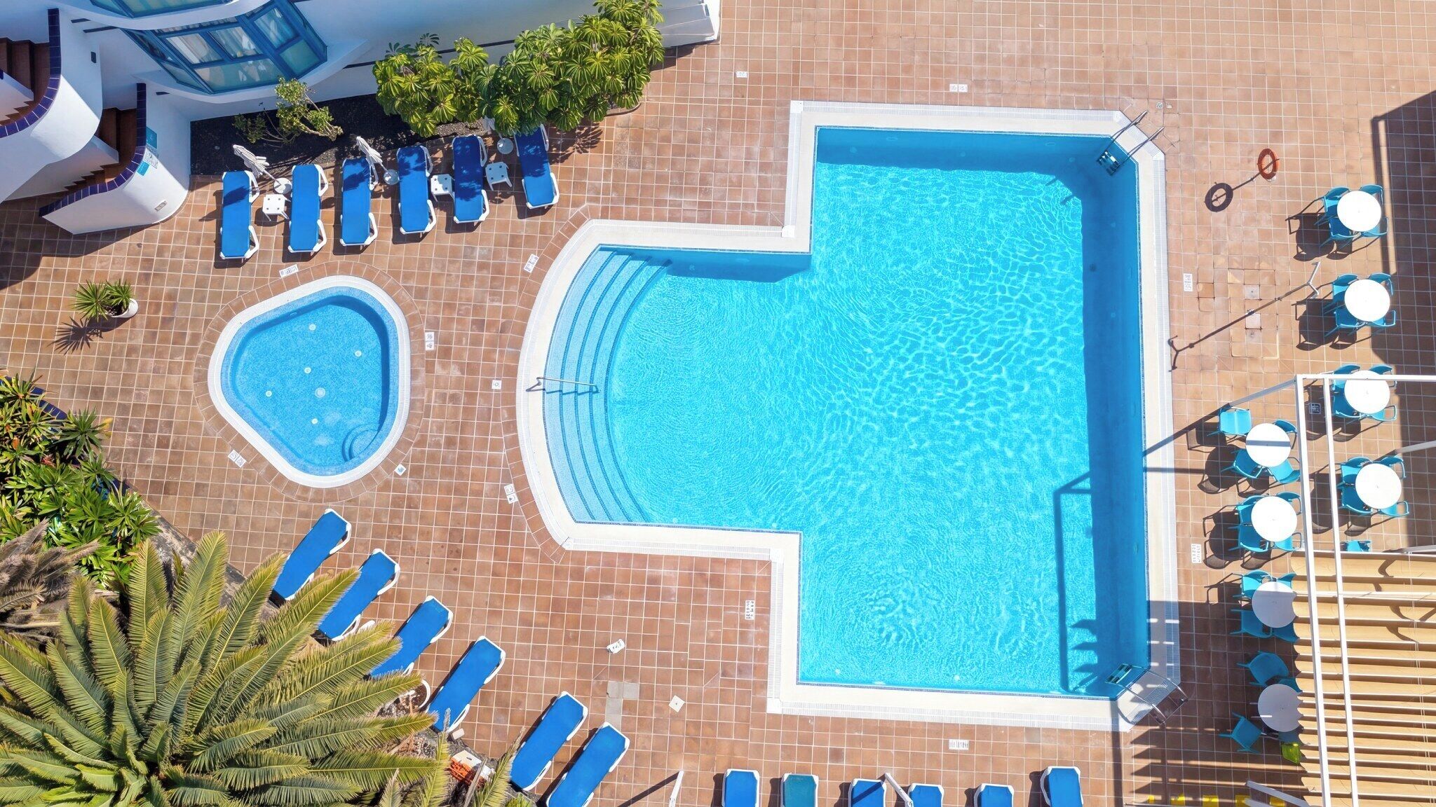 Une piscine sur le toit, dotée de plusieurs chaises longues et d’un jacuzzi.