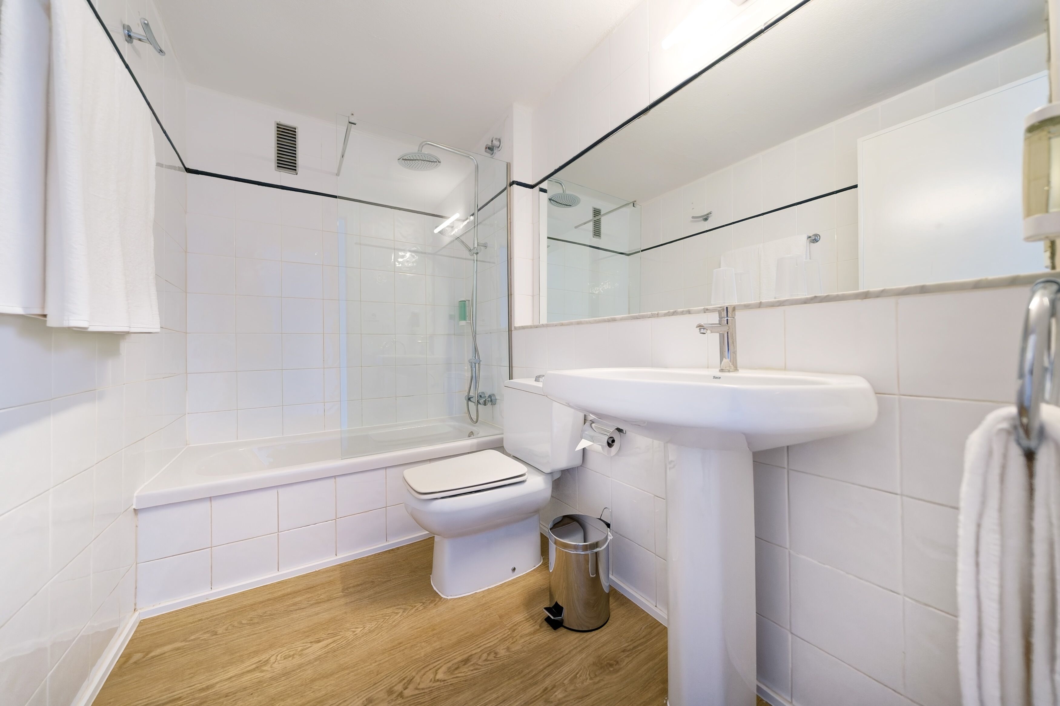 A modern bathroom with a bathtub, toilet, and shower area.