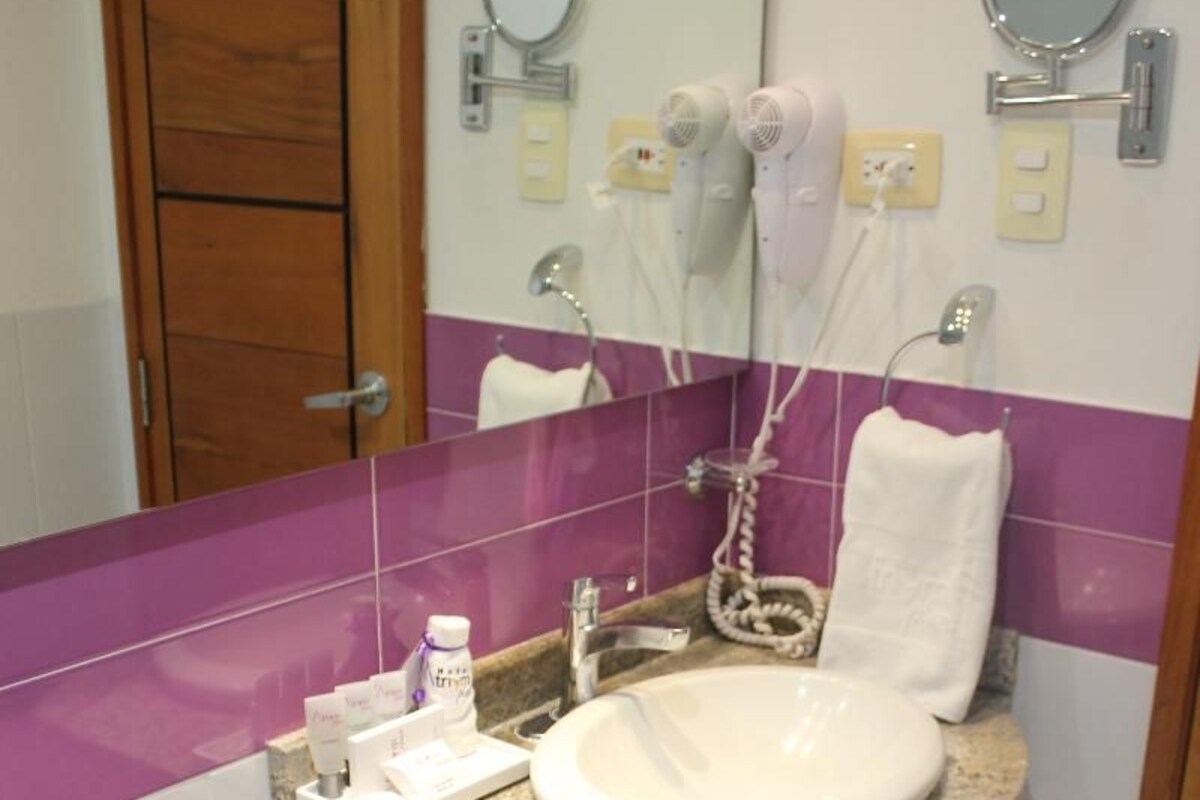 A bathroom with a granite countertop sink, a white toilet, and a mirror above the sink.