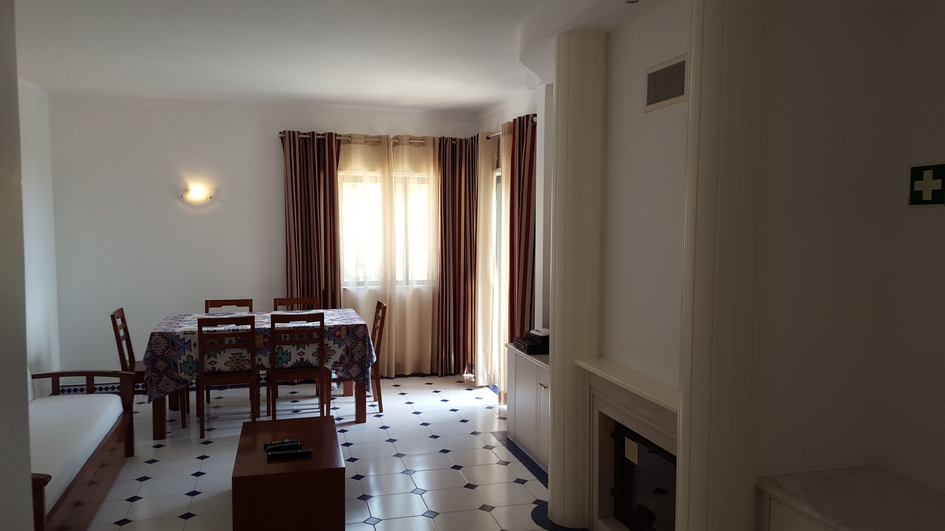 A dining area with a table and chairs, a fireplace, and a tiled floor.