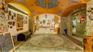 A room with a patterned carpet, stone walls, and a decorative ceiling. - Villa Asina (Datça)