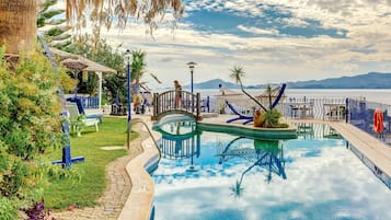 Relax by the serene pool surrounded by lush greenery and a picturesque view.