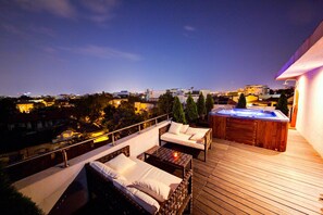 Relax on the rooftop with a hot tub and comfortable seating area overlooking the city.