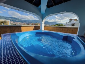 Una piscina en la azotea con vista a un paisaje urbano.