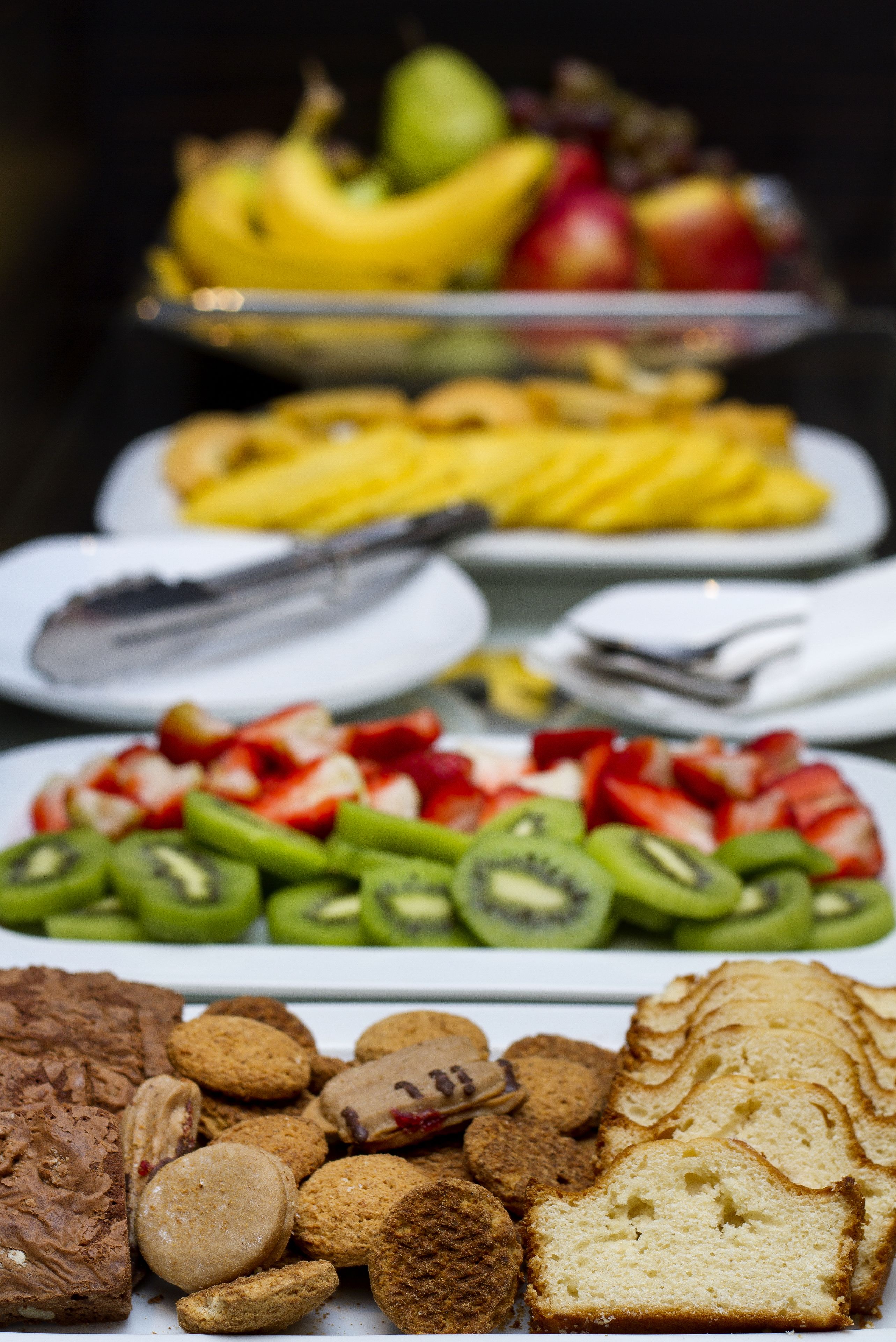 Diversos productos alimenticios, como frutas, pasteles y galletas, sobre una mesa.