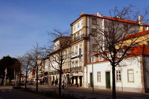Un hotel con fachada tradicional, varios pisos y tejado de tejas rojas.