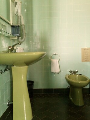 Un baño con lavamanos, bidé y toallero.