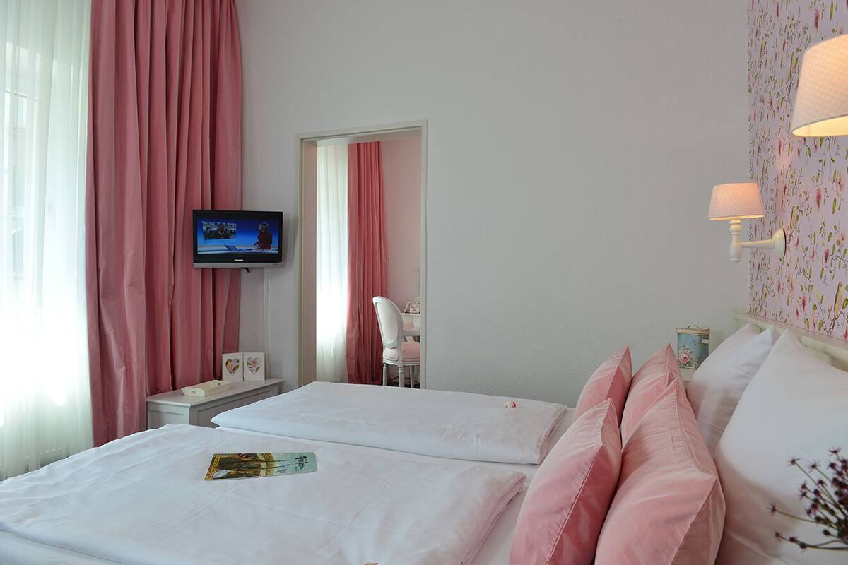Une chambre d’hôtel avec deux lits, une télévision, un bureau et une chaise.
