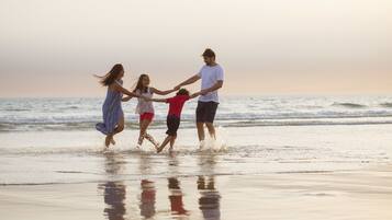 Aan het strand, wit zand, ligstoelen aan het strand, parasols
