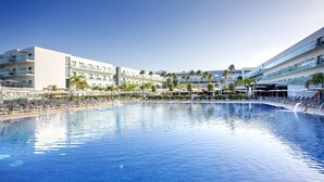 A modern hotel with a large swimming pool, multiple balconies, and palm trees. - Hipotels Gran Conil (Conil de la Frontera)