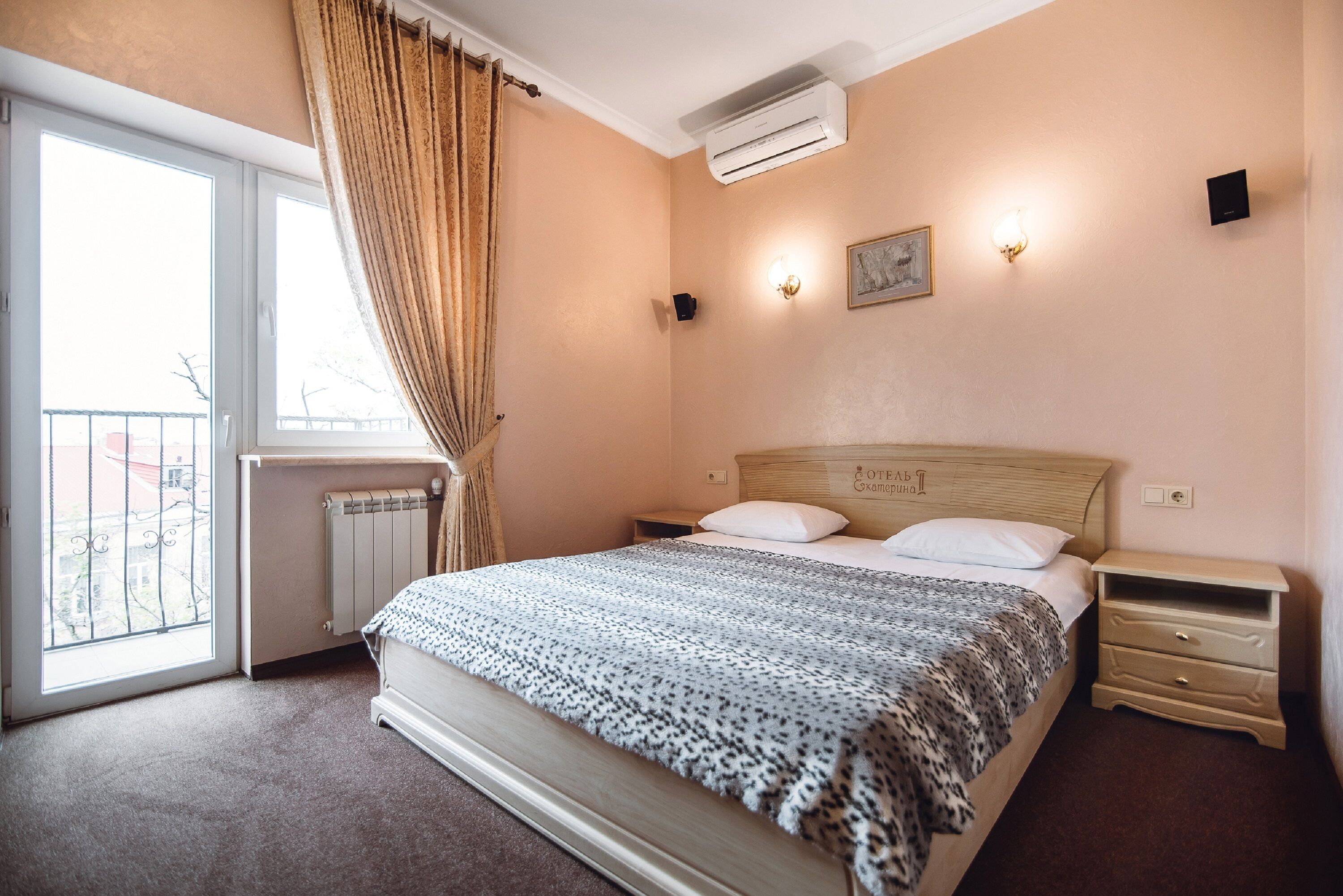 Une chambre à coucher comprenant un lit, une table de chevet, un radiateur, une fenêtre avec des rideaux et des lampes fixées au mur.