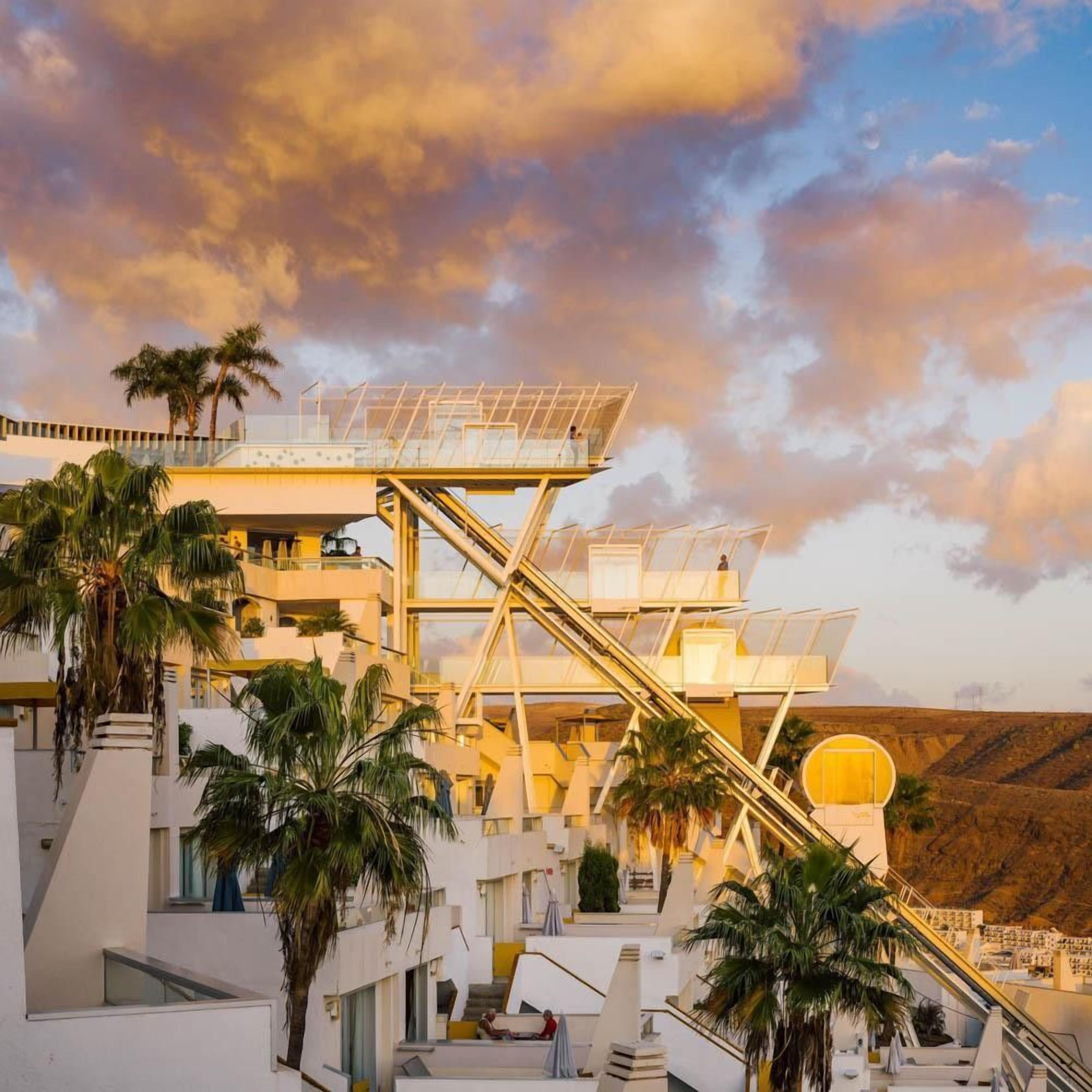 Un edificio moderno con un diseño arquitectónico distintivo, que presenta una escalera principal y varios balcones.