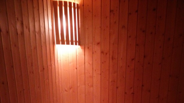 Ein Saunaraum mit Holzwänden und einer Sitzbank.