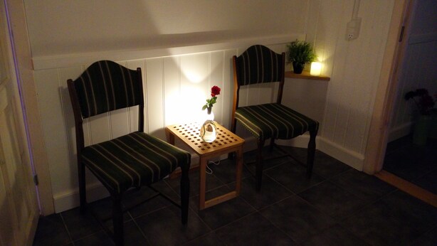 Two striped chairs with a small table and a vase with a single flower between them. - BB Esbjerg (Esbjerg)