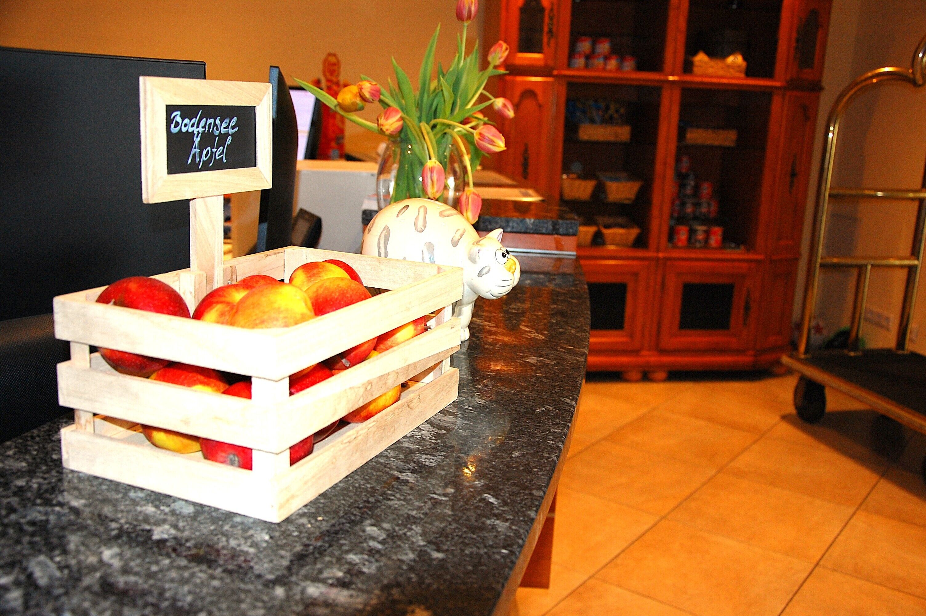 Una caja de madera con manzanas y un letrero que dice “Bodensee Hotel”.