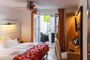 Una habitación de hotel con cama, escritorio, silla y vistas al exterior.