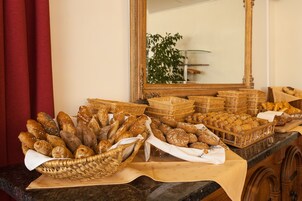 Una mesa de buffet con panes y pastelería variados.