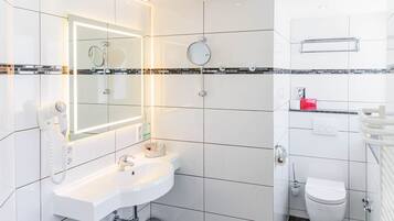 Ein modernes Badezimmer mit einem weißen Waschbecken, Spiegel und WC.