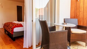 A bedroom with a bed, a bedside table, and a ceiling fan. - Bodensee-Hotel Kreuz (Uhldingen-Muehlhofen)