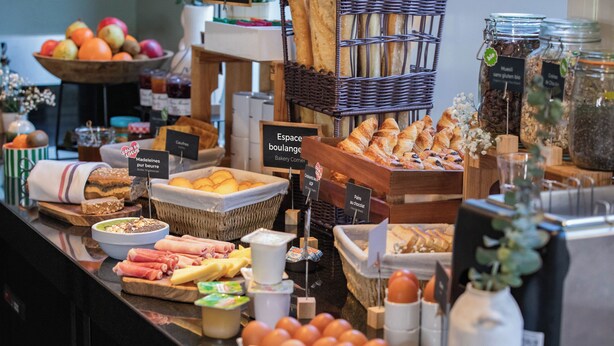 A bakery counter with various breads, pastries, and breakfast items. - Appart'City Confort Tours (Tours)