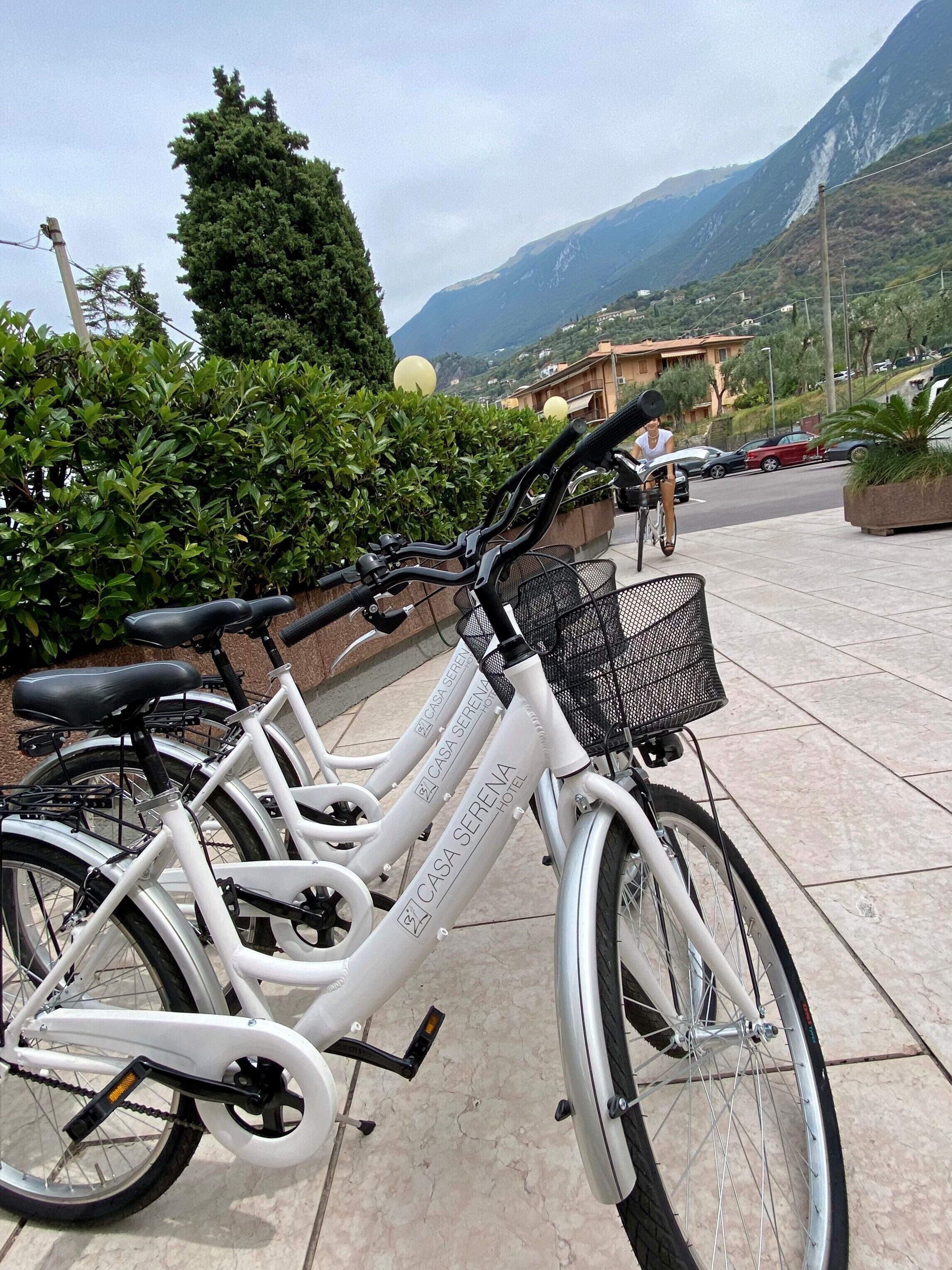 Ein weißes Fahrrad mit Korb, auf einer gefliesten Fläche abgestellt.